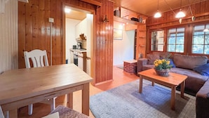 A wooden interior with a dining table, a sofa, and a coffee table. - Vacation home in Wulsbüttel - Enjoy your vacation in Cuxland (Hagen im Bremischen)
