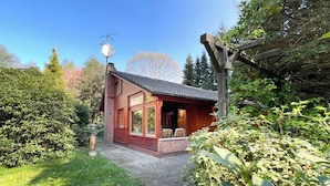 A wooden cabin with a sloped roof, large windows, and a satellite dish. - Vacation home in Wulsbüttel - Enjoy your vacation in Cuxland (Hagen im Bremischen)