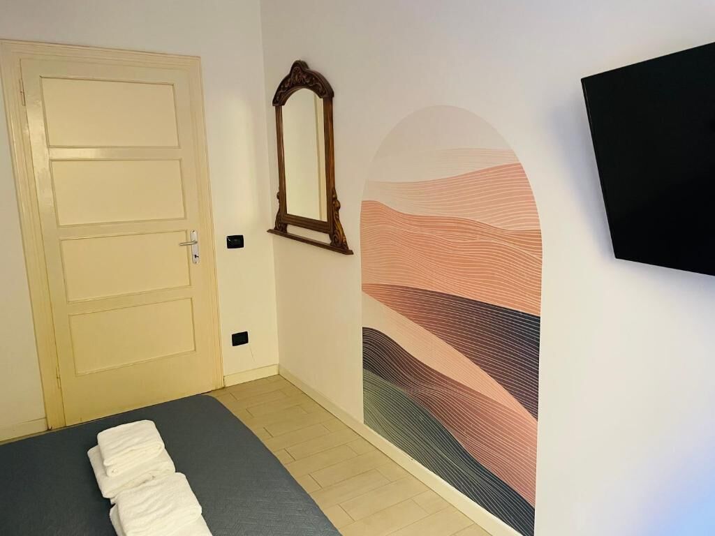 Quarto com cama, porta, espelho e parede com design texturizado.