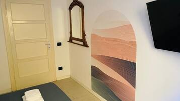 Quarto com cama, porta, espelho e parede com design texturizado.