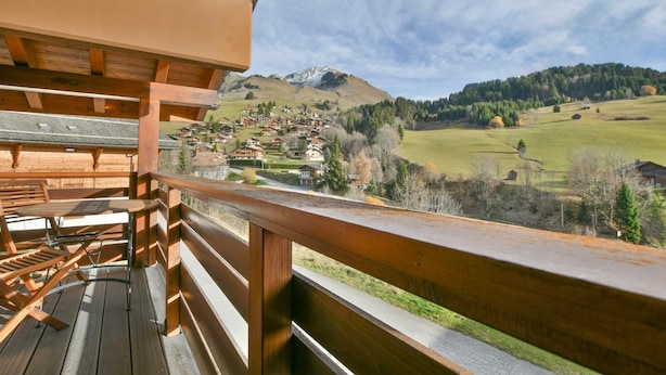 A wooden deck with a view of a village and mountains. - Cosy 6-person apartment in Chinaillon (Le Grand-Bornand)