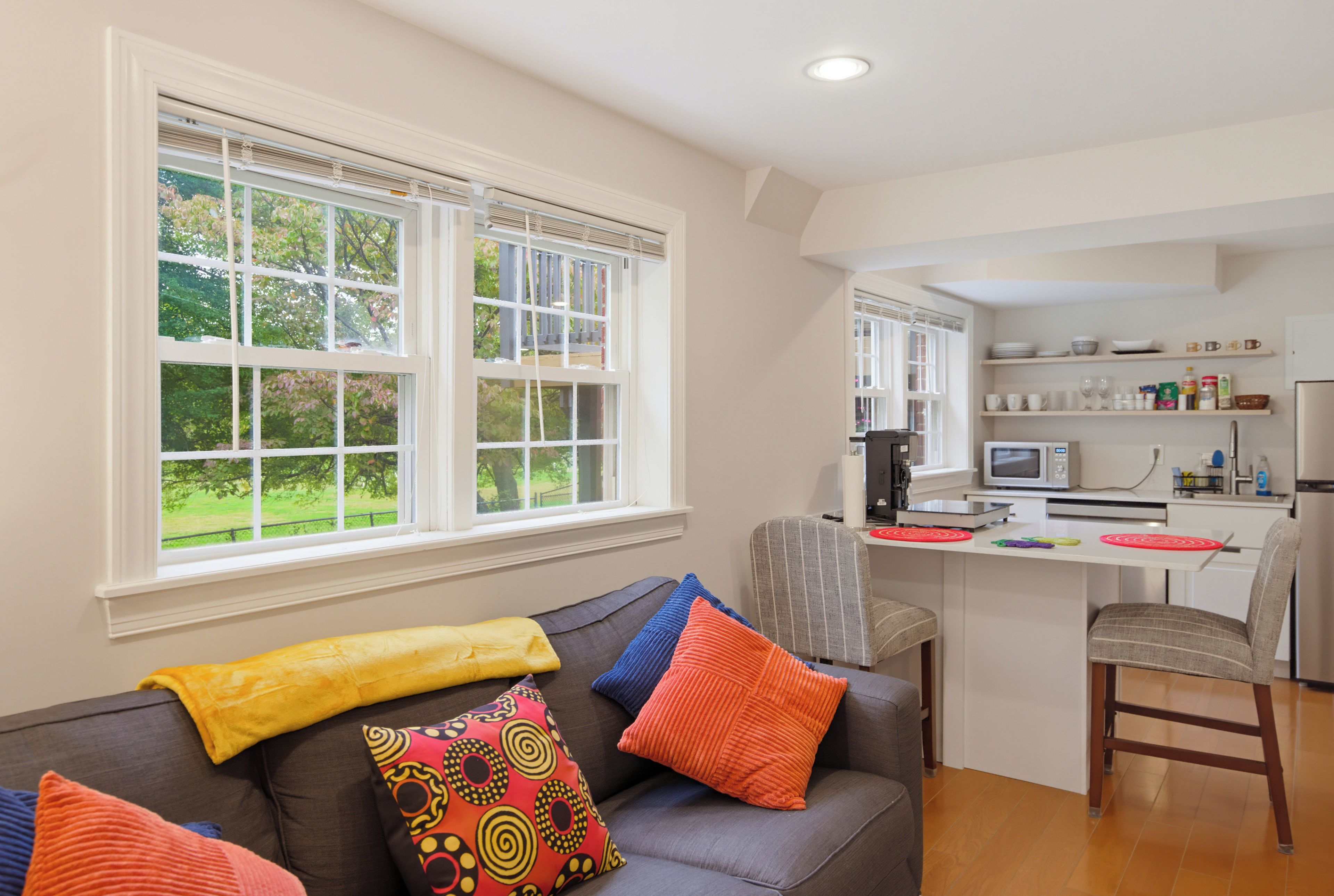 A modern kitchen with white cabinets, a microwave, and a coffee maker.