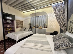 Un dormitorio con dos camas, un armario, un espejo y una ventana con cortinas.
