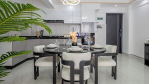 Een moderne eetruimte met een ronde tafel, zes stoelen en een decoratief middelpunt.