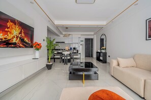 A modern living room with a flat-screen TV, a sofa, a coffee table, and a dining area with chairs. - Karibu Nairobi!
Jacy’s Cozy Apartment (Nairobi)