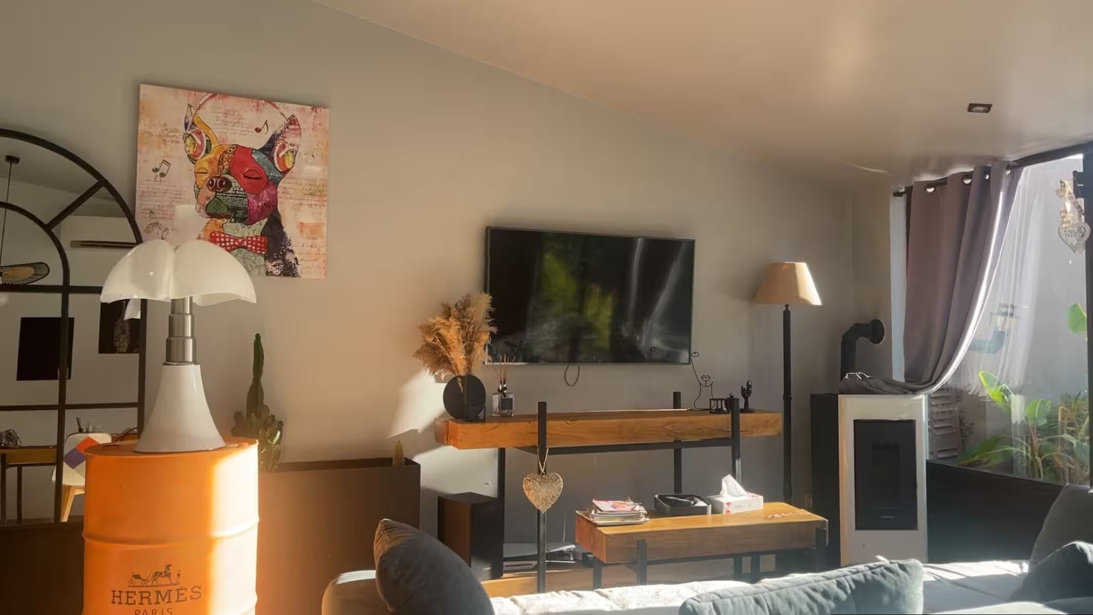 Una sala de estar moderna con un sofá, una mesa de centro, un televisor y una lámpara decorativa.