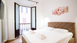 A bedroom with a bed, a balcony, and a wall-mounted artwork. - Brera-Moscova • Stile e Comfort in Centro (Milano)