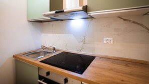 Een koelkast, een oven, een kookplaat, een koffiezetapparaat/waterkoker