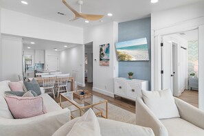 A spacious living area with a dining table, white furniture, and a ceiling fan. - Gulf front*Private Beach*Beach Chairs*Bikes (Santa Rosa Beach)