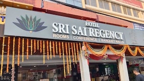 The exterior of the Sri Sai Regency Hotel, featuring a signboard with the hotel's name and services like rooms, conference, and banquet halls. - Hotel Sri Sai Regency (Hyderabad)