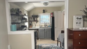 A kitchen with a window, a sink, and a countertop. There is a rug in the middle of the room. - Charming cottage in central Lafayette 8 min to Purdue (Lafayette)