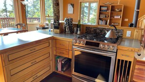 A modern kitchen with wooden cabinetry, a built-in oven, and a gas stove.