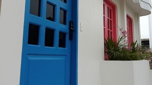 A building with a blue door, white walls, and a red window. - Miami Beach Hostel (Cartagena de Indias)