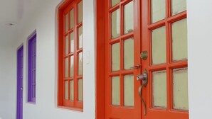 A hallway with two doors, one red and one purple, leading to rooms. - Miami Beach Hostel (Cartagena de Indias)