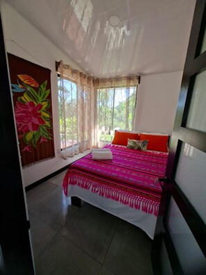 A bedroom with a bed, curtains, and a window. - NEW! Moody’s – Your Little Piece of Paradise (Savegre)