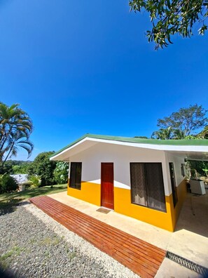 A single-story building with a flat roof, a wooden deck in front, and a clear blue sky in the background. - NEW! Moody’s – Your Little Piece of Paradise (Savegre)