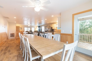 Gather everyone around this spacious dining table where memories are made over shared meals, with the open kitchen and wooded views creating perfect ambiance.