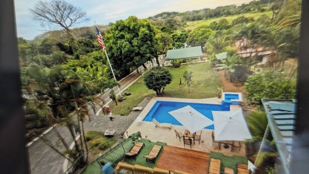 A fenced backyard with a swimming pool, lounge chairs, and a small deck. - Moody's Huts. 1-bedroom house in Savegre with AC, 5 minutes from Dominical Beach (Savegre)