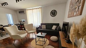 A living room with a sofa, two armchairs, a coffee table, and a clock on the wall. - Bella Vita - Apartment with free parking (Zagreb)