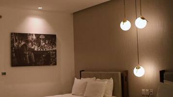 A hotel room with two beds, a wall-mounted picture, and a ceiling light fixture.