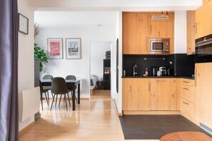 Una cocina moderna con armarios de madera, microondas y cafetera.
