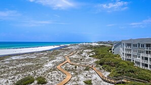 A coastal hotel with a sandy beach, a wooden boardwalk, and ocean views. - Top-Floor Gulf Views and Beach Access (Seacrest)