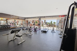 A gym with treadmills, weight machines, and a rowing machine.