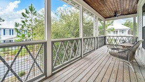 A covered porch with a wooden ceiling, a table and chairs, and a view of neighboring houses. - YOUR BEST BEACH VACATION EVER  POOL GOLF CART BIKES VERY CLOSE TO BEACH (Santa Rosa Beach)