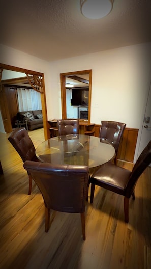 A dining area with a round glass table surrounded by six leather chairs. - Resort-Style Retreat w/ Pool, Prime OP Location (Mission)