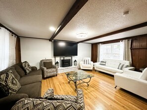 A living room with a fireplace, a TV, and a sofa. - Resort-Style Retreat w/ Pool, Prime OP Location (Mission)