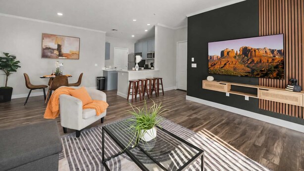 A modern living room with a sofa, a coffee table, and a TV mounted on the wall. - Scottsdale Desert Escape 2BR with Sunrise Peak Views, Pets OK (Scottsdale)