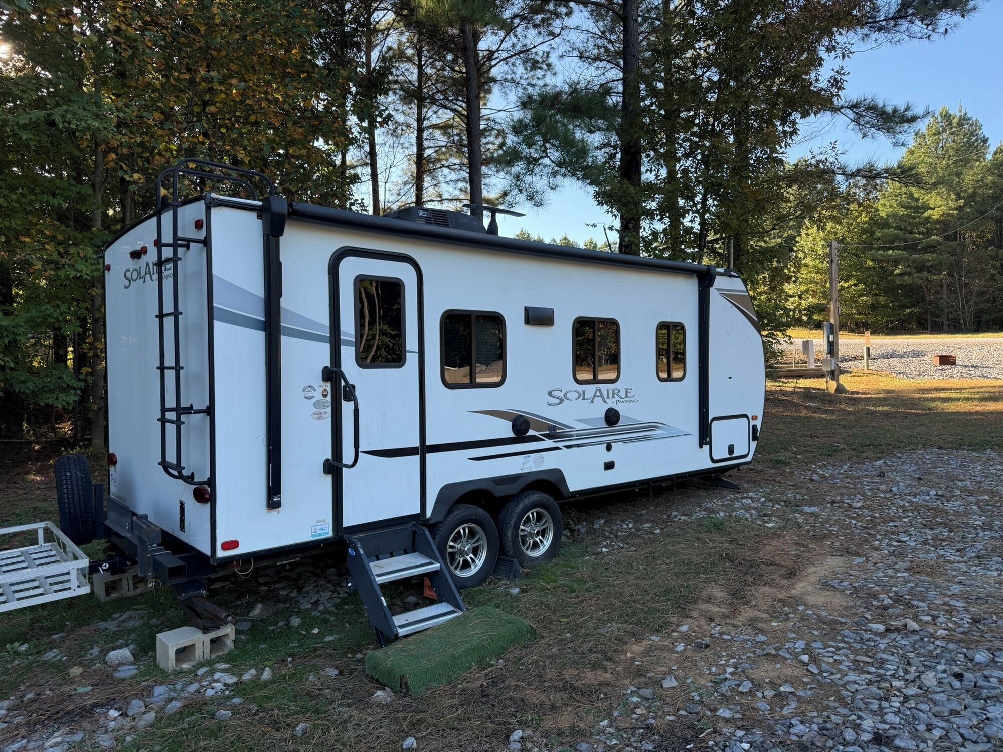 A white recreational vehicle with a ladder, windows, and the brand name 'Solaire'.
