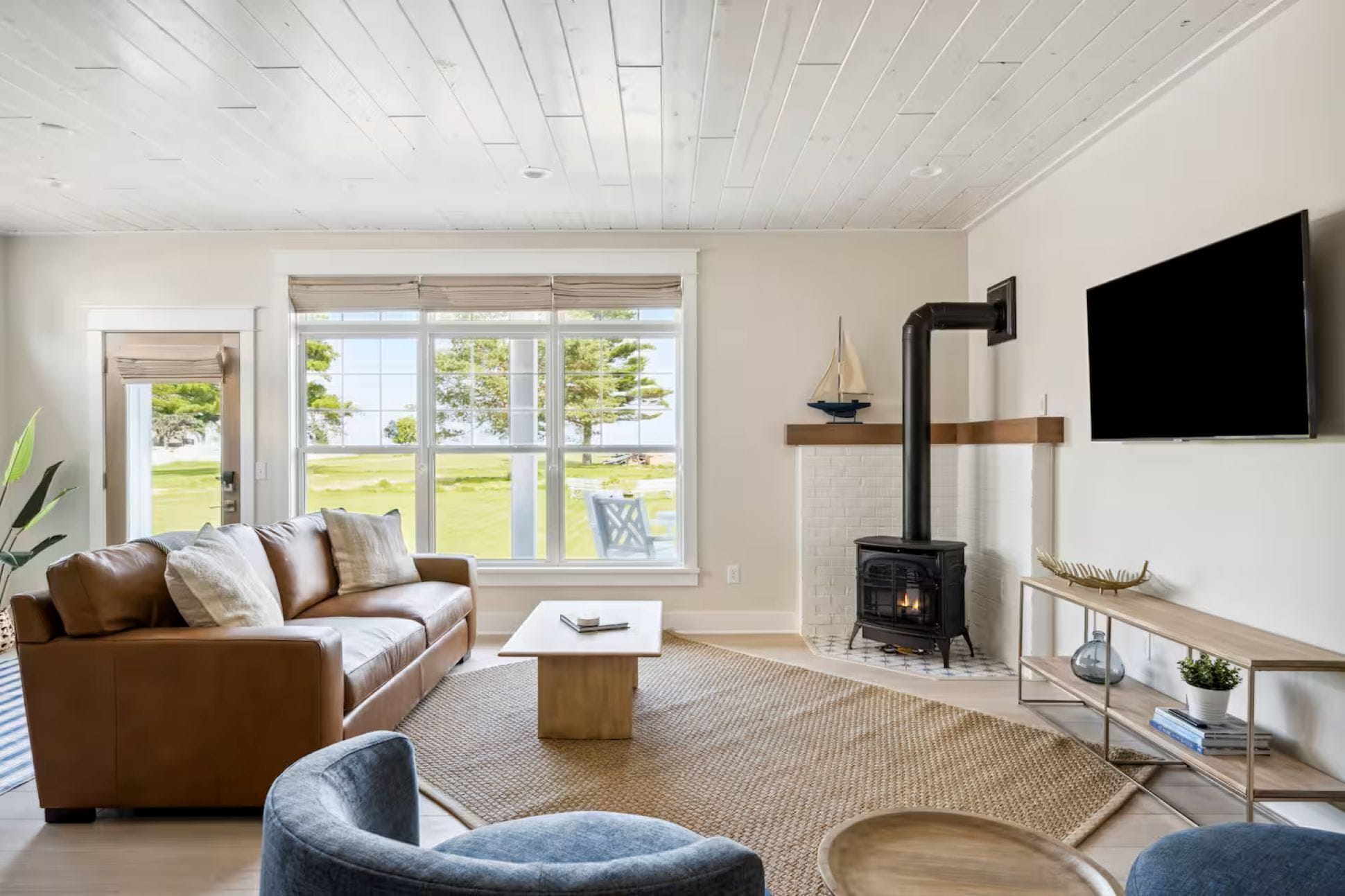 Una sala de estar moderna con chimenea, un sofá, una mesa de centro y un televisor montado en la pared.