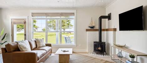 Una sala de estar moderna con chimenea, un sofá, una mesa de centro y un televisor montado en la pared.