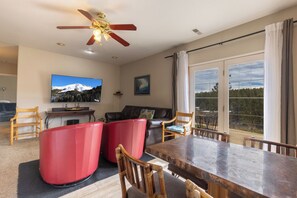 A spacious living area with a large TV, a dining table, and a balcony with a scenic view. - Spacious Pet-Friendly house in Durango (Durango)