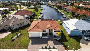 A residential area with houses, a canal, and a well-maintained lawn. - Sunset Retreat Pool/Spa, great views, we love dogs (Punta Gorda)