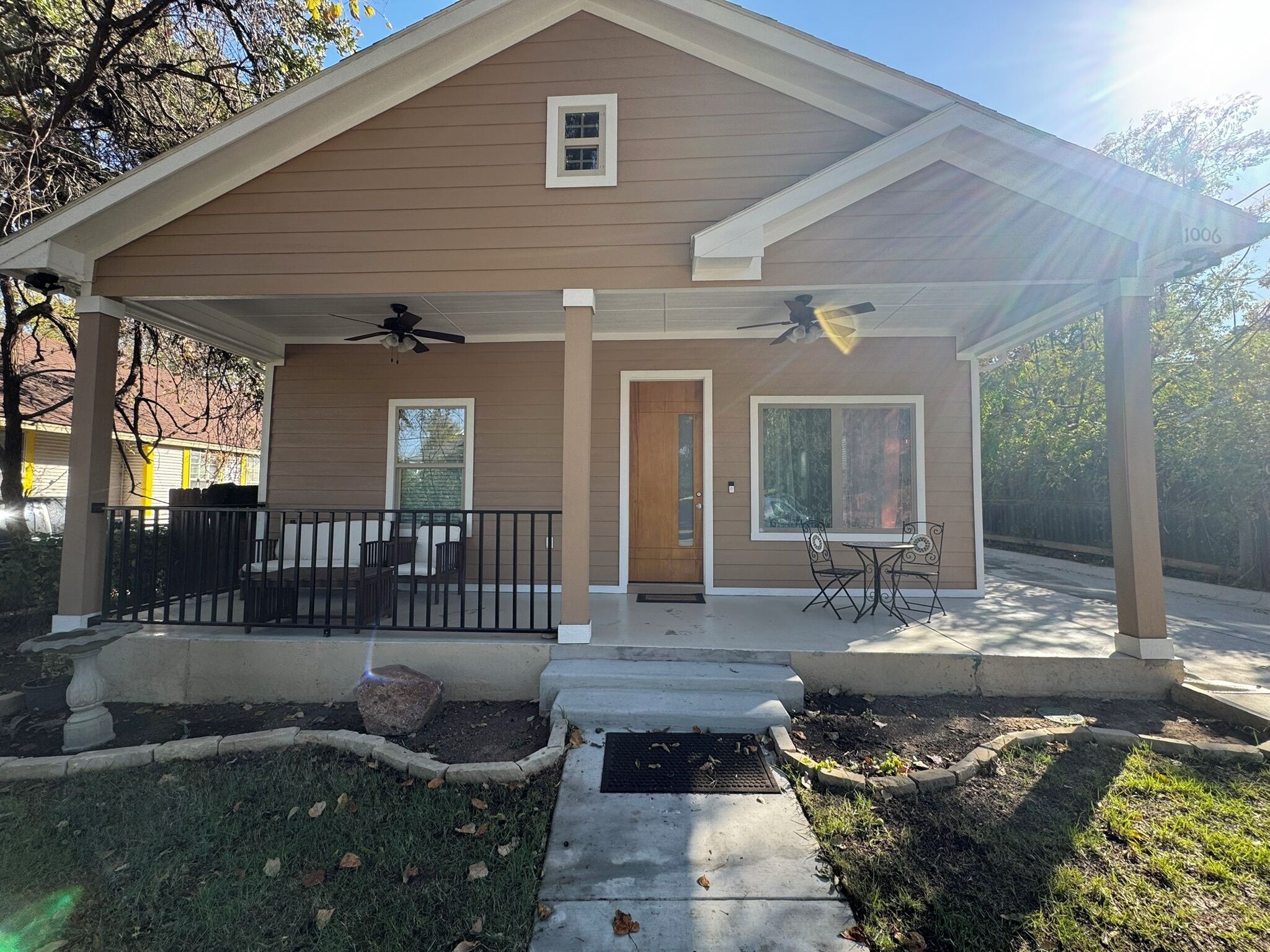 A two-story house with a covered porch, a front door, and a small window.