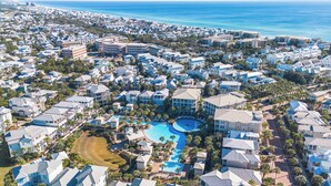 Eine Luftaufnahme eines Küstenresorts mit mehreren Gebäuden, einem zentral gelegenen Schwimmbecken und Blick auf den Ozean.