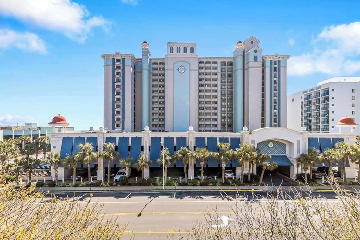 Un grand hôtel à étages multiples, doté d’un beffroi central et d’une façade symétrique.