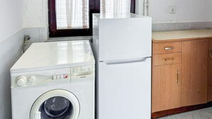 Eine kleine Küche mit Waschmaschine und Kühlschrank.