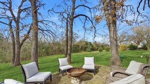 An outdoor seating area with wicker chairs and a fire pit.