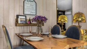 A dining table set with plates, glasses, and a vase of purple flowers. - Farm barn with territorial view in Banks w/ pheasants- 1 hour drive to coastal (Banks)