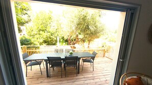 A wooden deck with a table and chairs, a white fence, and trees in the background. - Les Ondines - T3, Parking, Garden & Near center. (Collioure)
