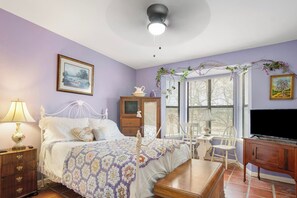Un dormitorio con cama, mesita de noche, cómoda y televisor.
