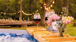A wooden tray with two wine glasses and a vase of flowers on a table outdoors. - Renovated Barn w/ Jacuzzi - Tree Table - 3 Acres (Ruckersville)