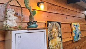 Pared de madera con un cactus, una figurita de conejo, una estatua de Buda y un cuadro de cebra.