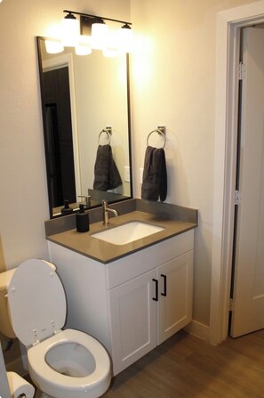 Chuveiro, toalhas de banho, sabonete, papel higiênico