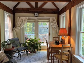 A cozy room with a wooden table, chairs, a potted plant, a clock, and a window with curtains. - Secluded 1-bedroom apartment in charming York (York)