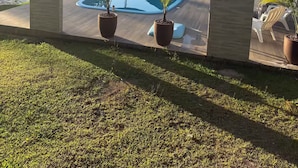 A pool area with potted plants and outdoor furniture. - Chalet/Country House in the Serra SC area for friends and family, sleeps up to 15 people. (Anitápolis)