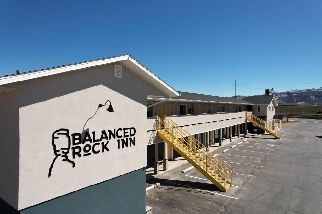 Un edificio con un letrero que dice 'Balanced Rock Inn' y un estacionamiento.